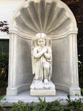 Mooi knielend engelbeeld vol steen in bidkapel vol steen.